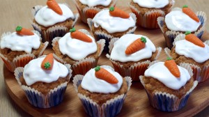 Wortelcupcakes bij elkaar, met witte glazuur en een oranje worteltje erop