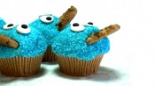 Vier blauwe koekiemonstercupcakes met blauwe kokos en koekjes