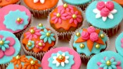 Bollywoodcupcakes met oranje, roze en blauwe marsepein en gouden parels