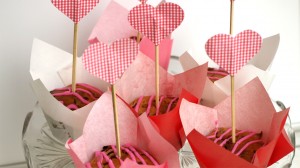 Valentijnsmuffins met frambozen, witte chocola en rode cupcaketoppers in de vorm van een hartje